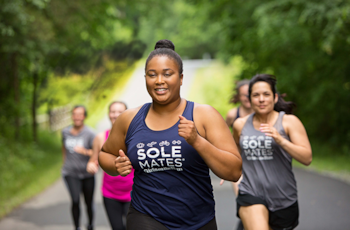 Solemates participant smiles while running outdoors